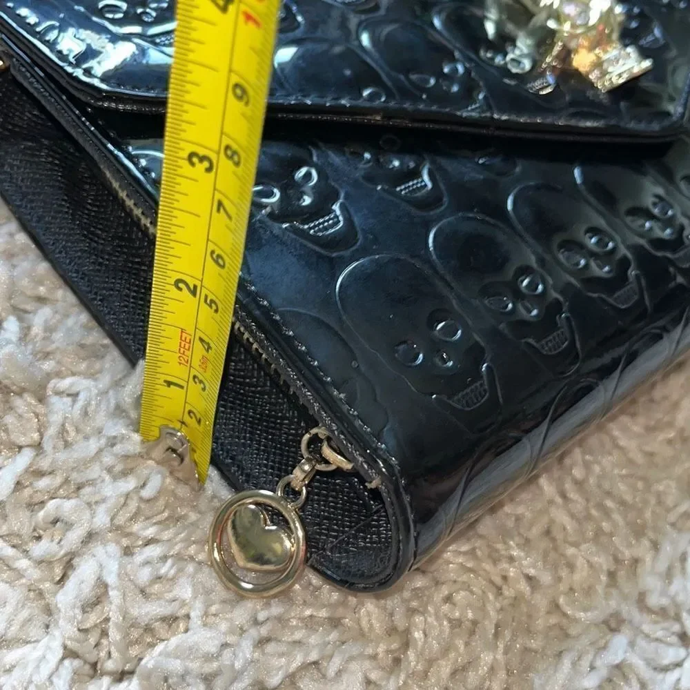 Awesome patent leather skull embossed clutch bag with gold chain shoulder strap.